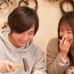 初デートで笑いながらブレスレット作るカップルの様子