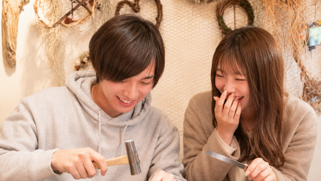 初デートで笑いながらブレスレット作るカップルの様子