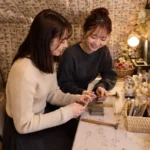 池袋で久しぶりに会った友達同士が近況を話しながら真鍮バングルを作る様子
