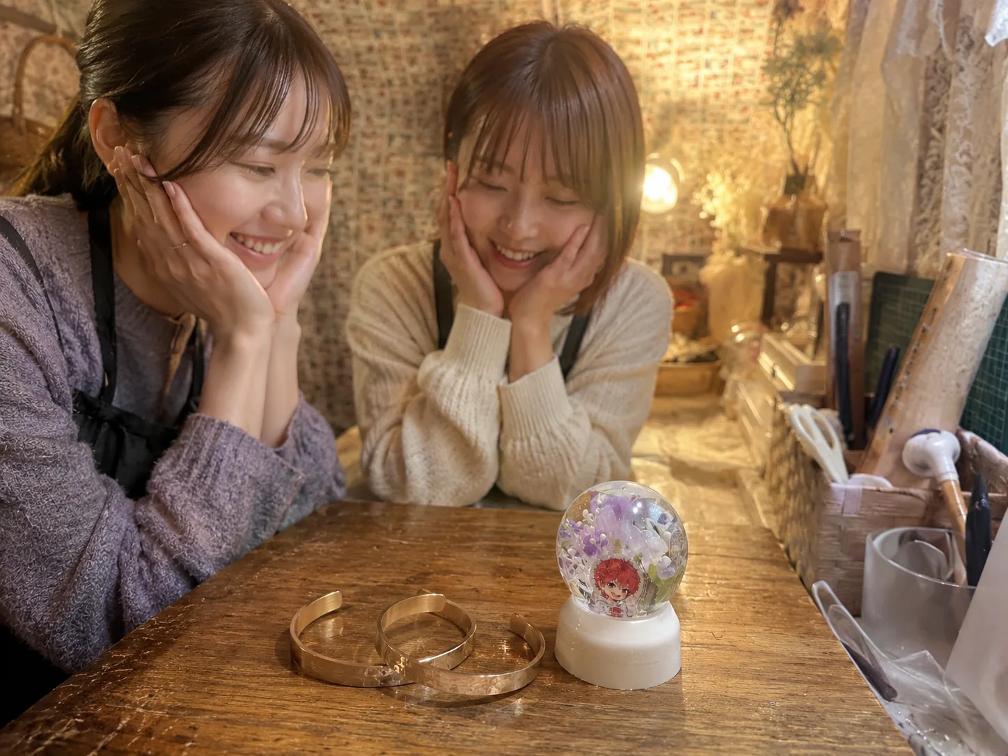 完成した真鍮バングルと写真入りスノードームを見て笑顔になる二人